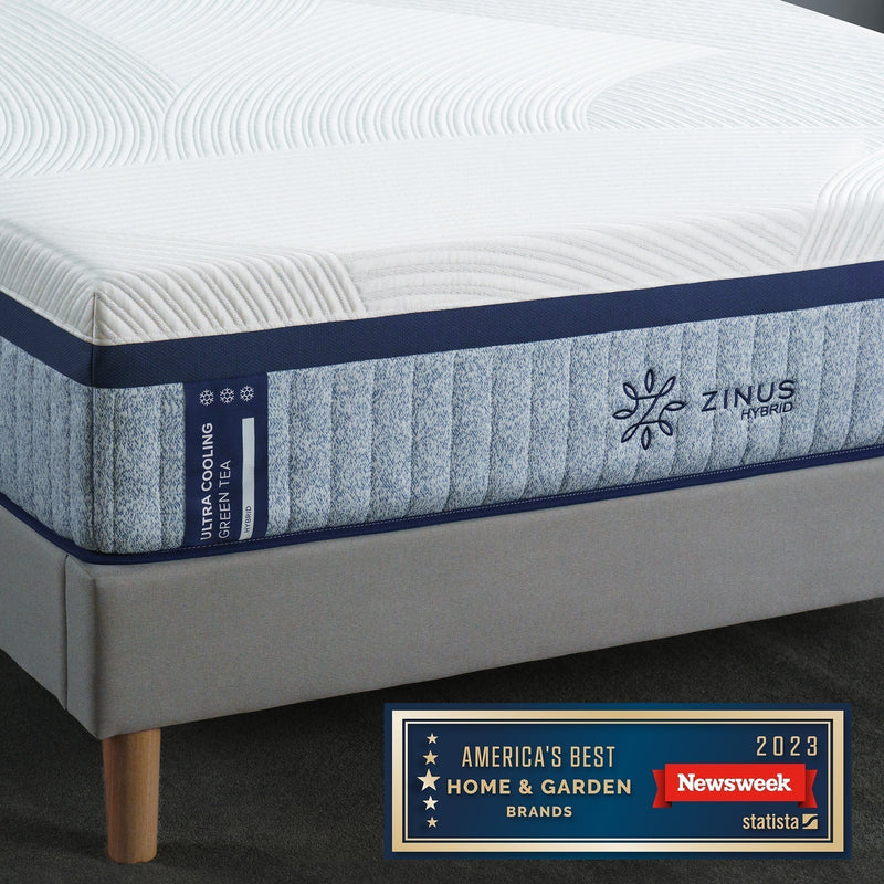 Close-up of a Zinus hybrid mattress with a textured white cover and blue Ultra Cooling Green Tea label, shown beside a 2023 Newsweek award badge for best home and garden brands.