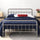Zinus Florence Metal Platform Bed Frame with headboard, styled with blue bedding and a wicker storage basket beneath. Sturdy steel frame adds modern farmhouse charm while supporting queen or full mattresses with underbed storage space