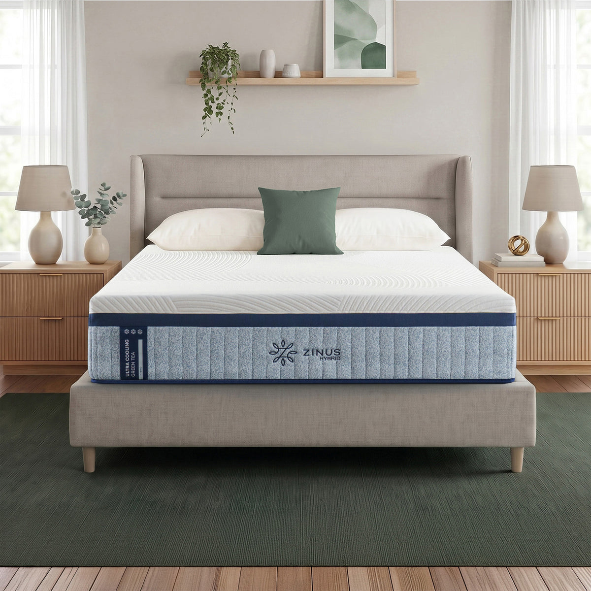 Zinus Balanced Comfort Luxe Hybrid Mattress fully set up on an upholstered platform bed with paneled headboard in a bright bedroom with white and green pillows, nightstands, and lamps on either side, showing the mattress in its intended home setting.
