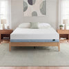 Zinus Balanced Comfort Core Memory Foam Mattress fully set up on a natural wood platform bed frame in a light, airy bedroom with white and green pillows, nightstands, and lamps on either side, showing the mattress in its intended home bedroom setting.