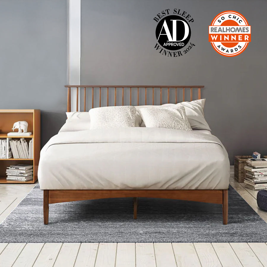 Best Sleep Winner 2024 AD Approved badge and Real Homes So Chic Awards Winner badge. Zinus wood slat bed with white bedding styled in a minimalist gray-walled bedroom with bookshelf and neutral rug, emphasizing award-winning comfort and timeless design.