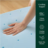 Close-up of a hand pressing into a blue cooling memory foam topper with airflow holes, promoting 7-zone support and cooling comfort