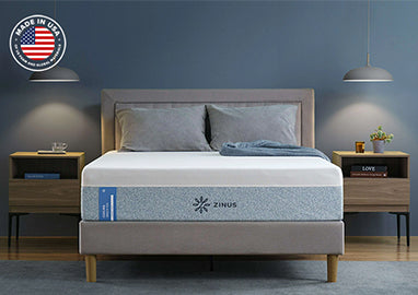 Zinus Cooling mattress with breathable cover on upholstered platform bed with gray headboard, styled in modern bedroom with wooden nightstand, gray bedding, and pendant light.