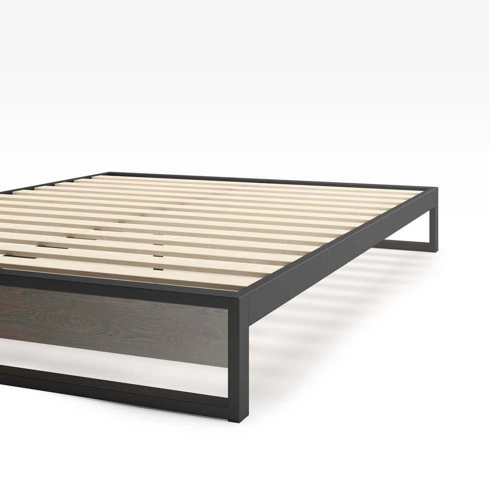 Close-up of Zinus Suzanne Metal and Bamboo Platform Bed Frame corner detail. Shows black steel frame construction, bamboo wood accent, and slatted mattress base. Sturdy design built for long-lasting durability and modern bedroom style