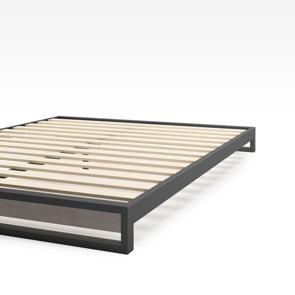 Close-up of Zinus Suzanne Metal and Bamboo Platform Bed Frame corner detail. Shows black steel frame construction, bamboo wood accent, and slatted mattress base. Sturdy design built for long-lasting durability and modern bedroom style