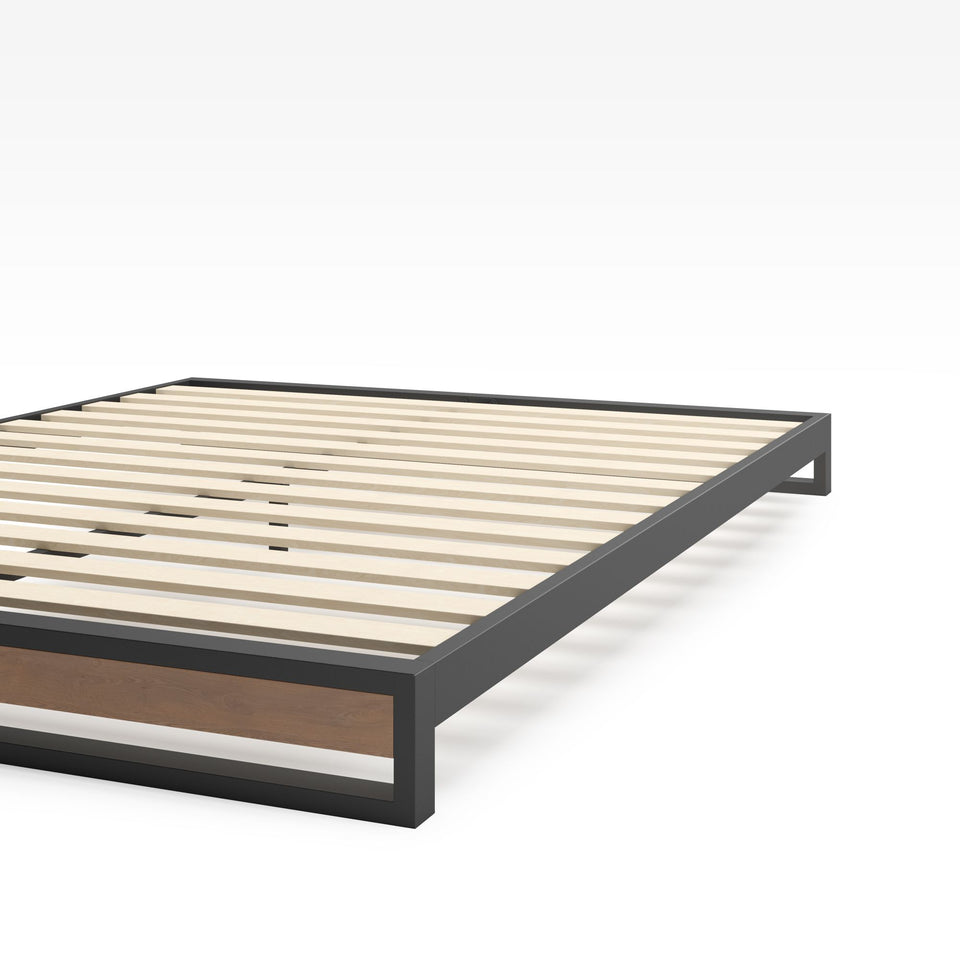 Close-up of Zinus Suzanne Metal and Bamboo Platform Bed Frame corner detail. Shows black steel frame construction, bamboo wood accent, and slatted mattress base. Sturdy design built for long-lasting durability and modern bedroom style